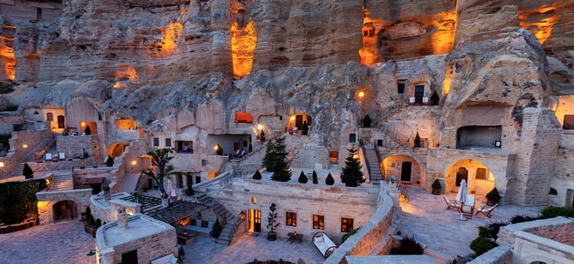 Rooms are accessed through a labyrinth of narrow passageways and curved stone stairways on multi-level plateaus.